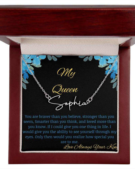 A polished stainless-steel signature name necklace in a mahogany box with a to my queen greeting card.