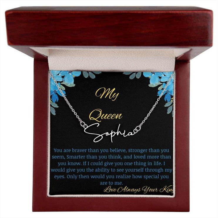 A polished stainless-steel signature name necklace in a mahogany box with a to my queen greeting card.