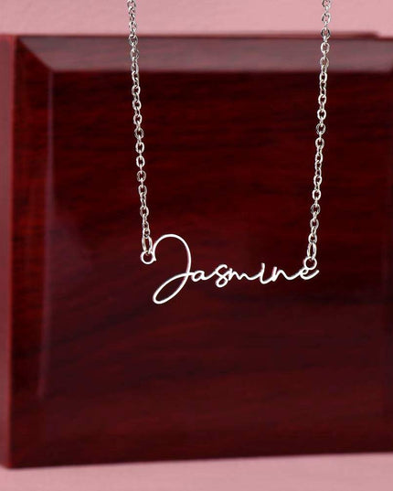 stainless-steel signature name necklace on top of a closed luxury box