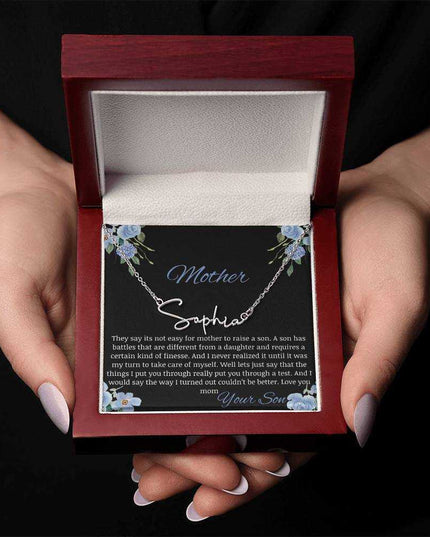 A polished stainless-steel signature name necklace in a mahogany box in a models hands