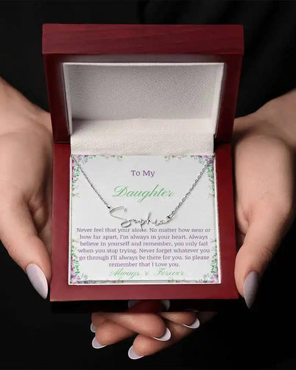 a polished stainless steel signature name necklace in mahogany box in a models hands