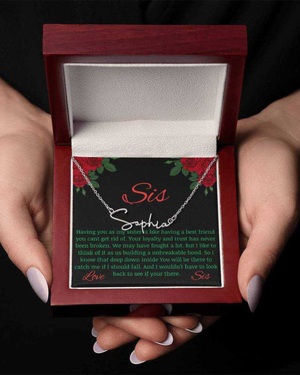 Signature Style Name Necklace with a polished stainless-steel variant on a To Sis from Sis greeting inside a mahogany box in the hands of a model.