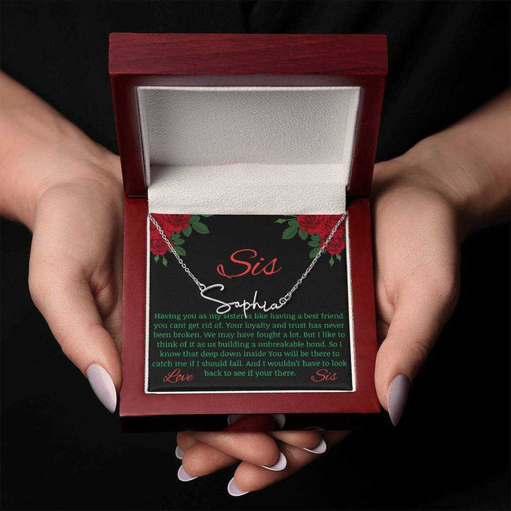 Signature Style Name Necklace with a polished stainless-steel variant on a To Sis from Sis greeting inside a mahogany box in the hands of a model.