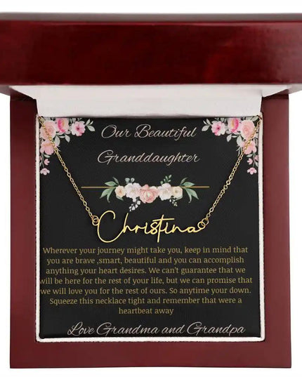 Signature Name Necklace with a yellow gold finish and a to granddaughter from grandma and grandpa greeting card in a mahogany box up close