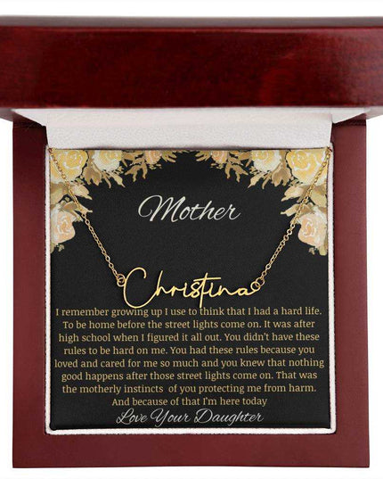 A yellow gold finish signature name necklace in a mahogany box.