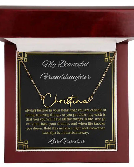 Signature Name Necklace with a yellow gold finish and a to granddaughter from grandpa greeting card in a mahogany box angled to the right