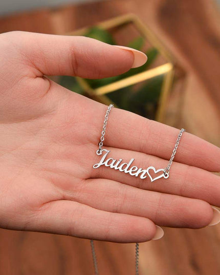 polished stainless-steel name heart necklace in the palm of a model's hands