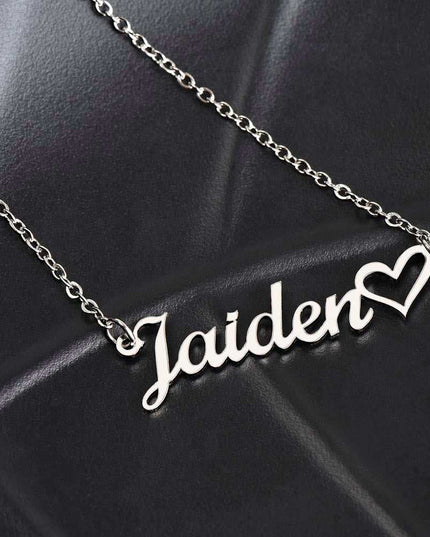 polished stainless-steel name heart necklace on a black seat