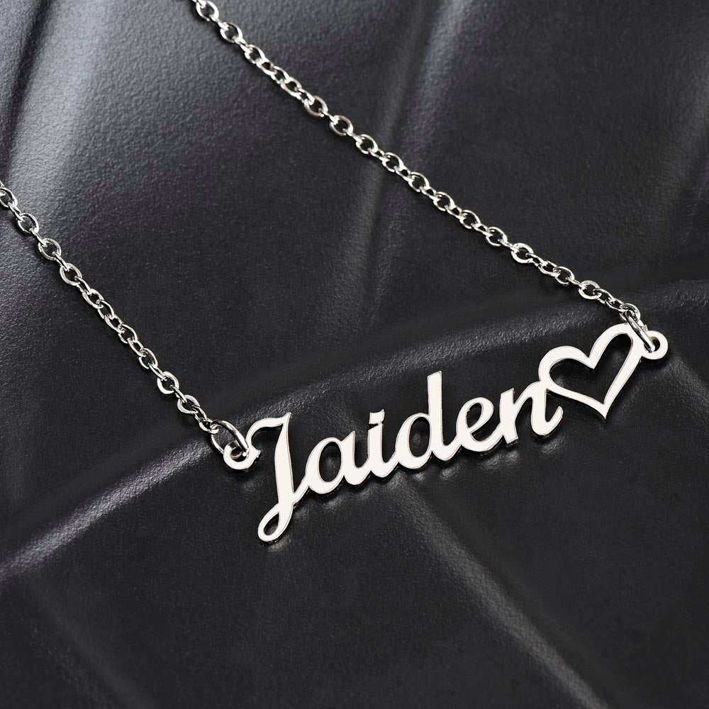 polished stainless-steel name heart necklace on a black seat