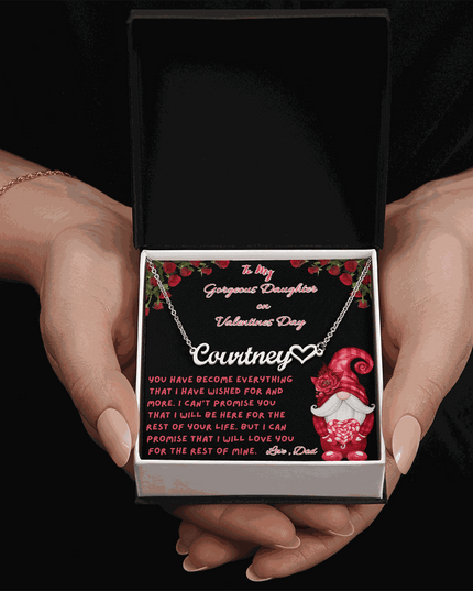 polished stainless-steel name heart necklace in a soft box in a model's hands