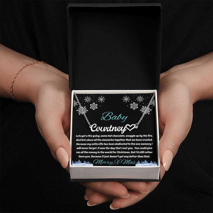 stainless-steel name heart necklace in soft box in model's hands