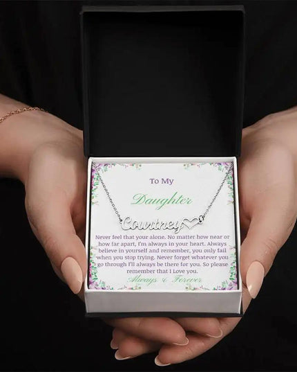 A polished stainless-steel name heart necklace in models hands