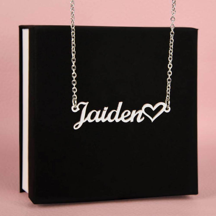 stainless-steel name heart necklace on top of a soft box 