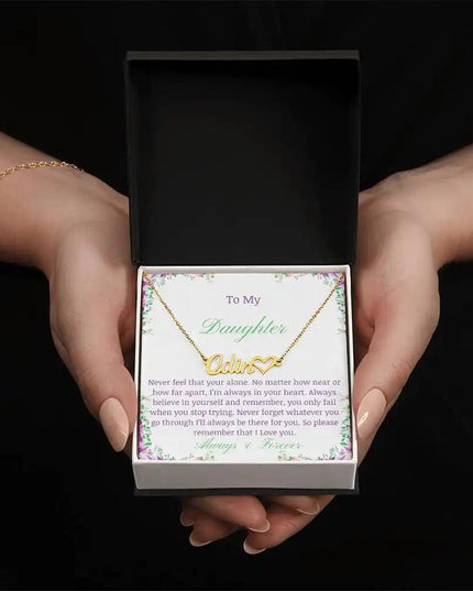 A yellow gold name heart necklace in models hands