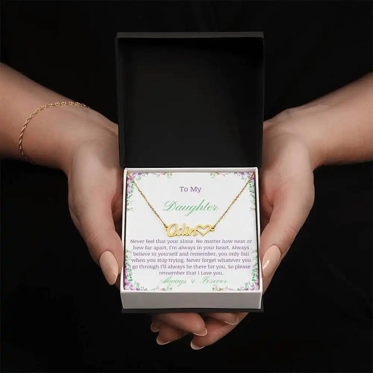 A yellow gold name heart necklace in models hands