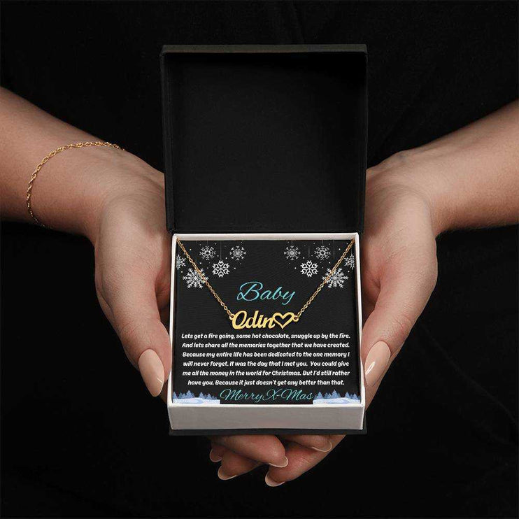 gold name heart necklace in soft box in model's hands