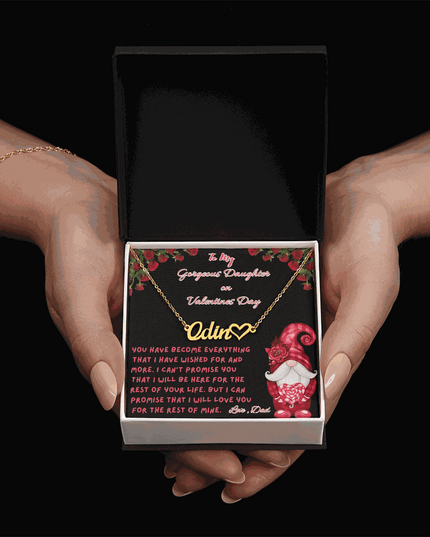 yellow gold name heart necklace in a soft box in a model's hands