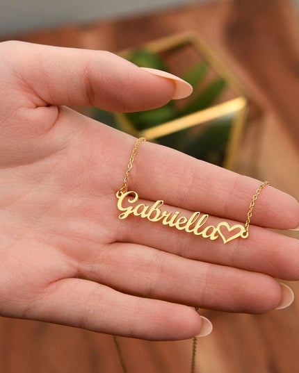 gold name heart necklace in a model's hand