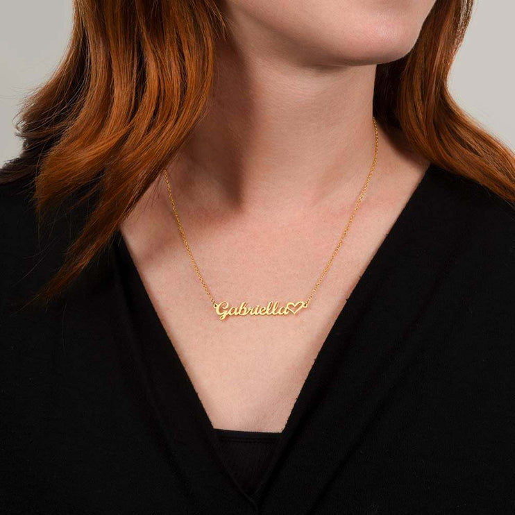 gold name heart necklace on a model's neck