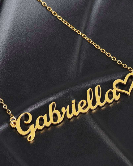 gold name heart necklace on a black cushion
