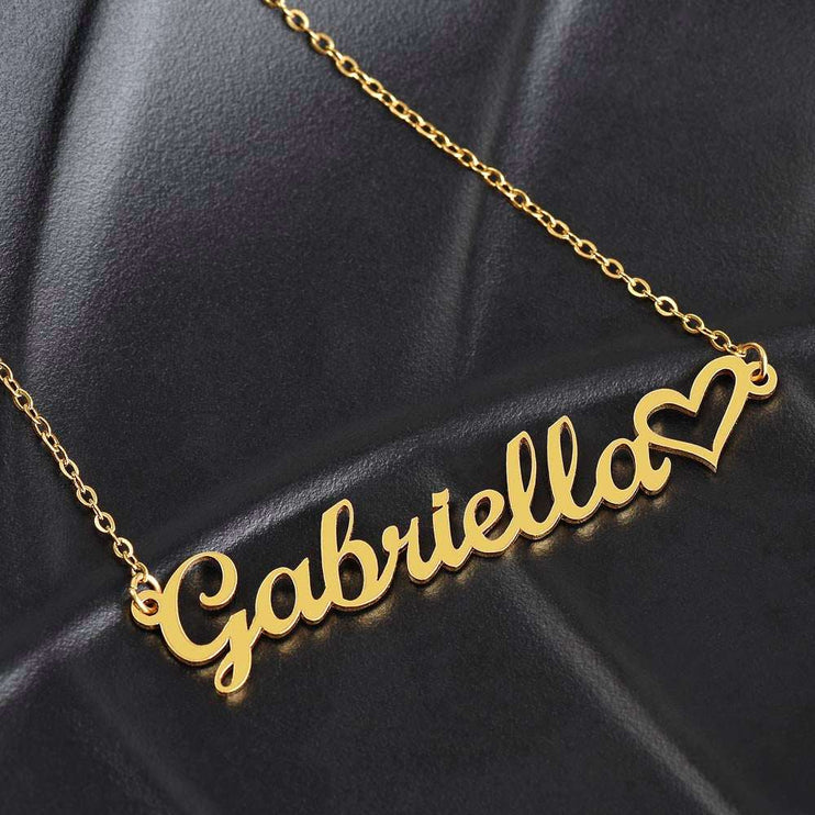 gold name heart necklace on a black cushion