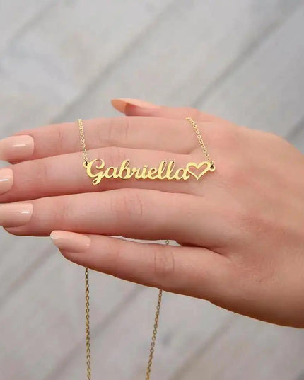 gold name heart necklace on model's hand