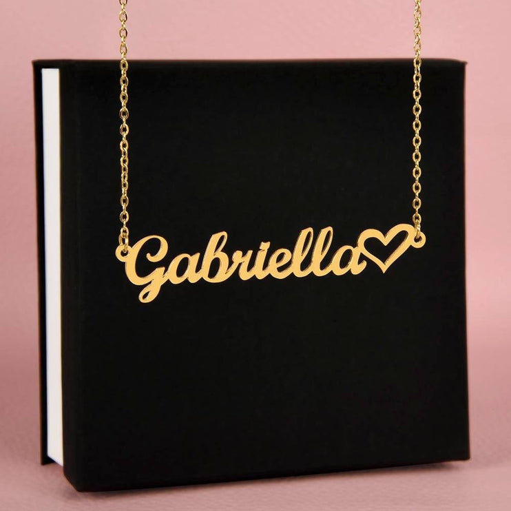 gold name heart necklace on top of a closed soft box