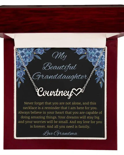 Name Heart Necklace with a polished stainless-steel charm on a to granddaughter from grandma greeting card in a mahogany box in a models hands