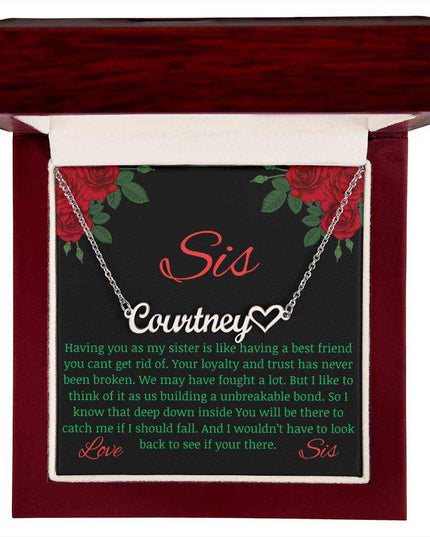 Name Heart Necklace with a polished stainless-steel variant on a To Sis from Sis greeting card inside a mahogany box up close view.