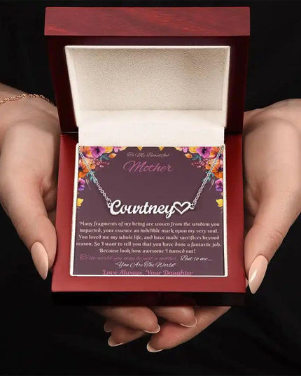 polished steel name heart necklace in mahogany box in model's hand