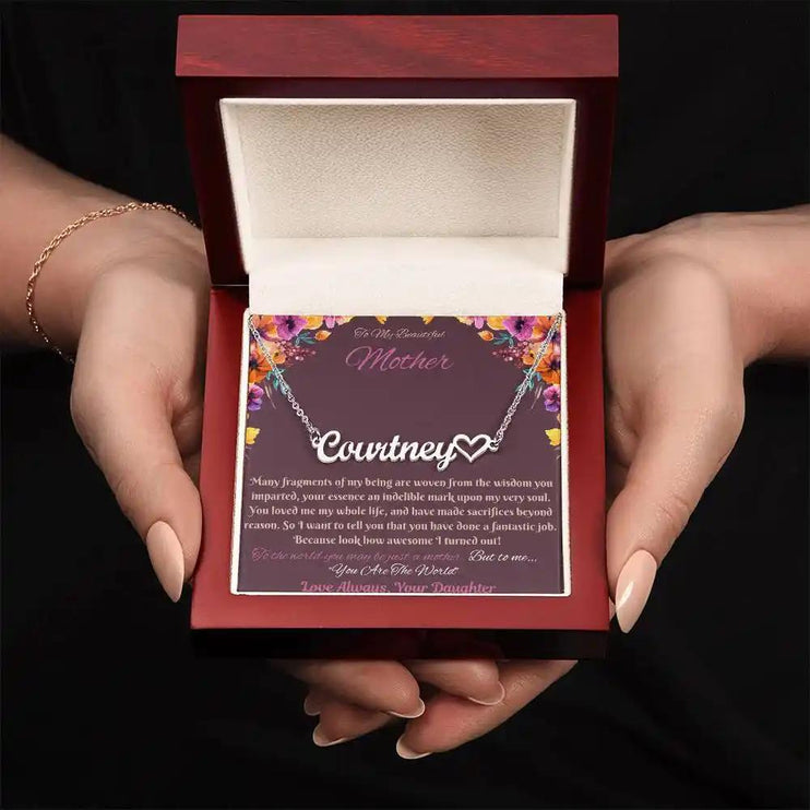 polished steel name heart necklace in mahogany box in model's hand