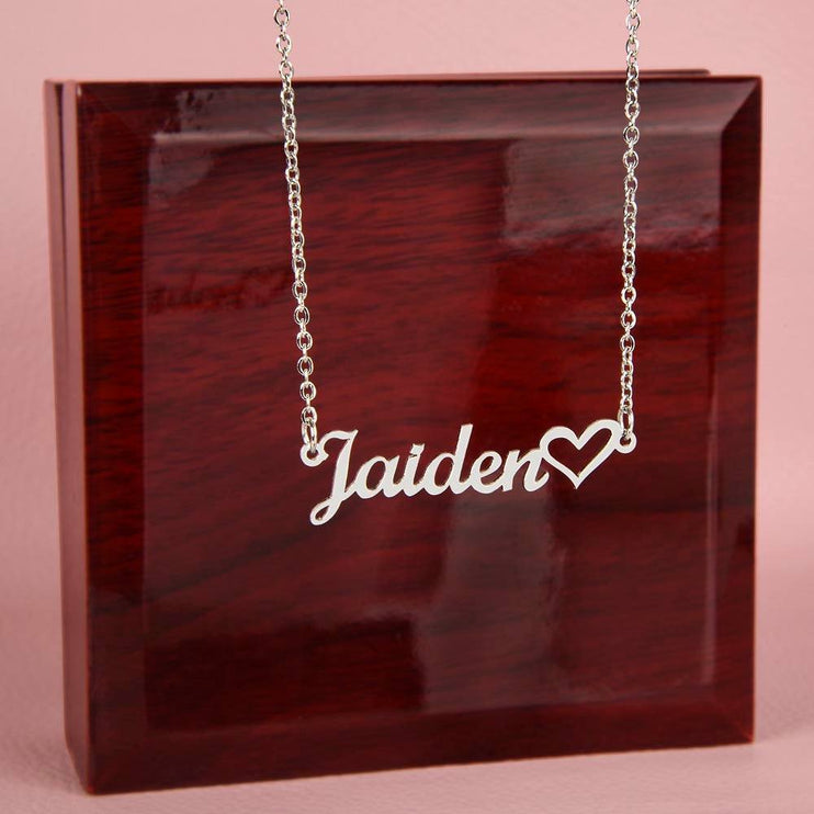 stainless-steel name heart necklace on top of a closed luxury box