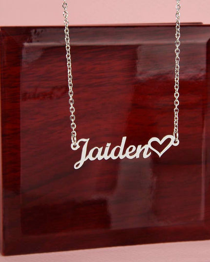 polished stainless-steel name heart necklace on top of a luxury box