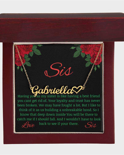 Name Heart Necklace with a yellow gold finish variant on a To Sis from Sis greeting card inside a mahogany box up close view .
