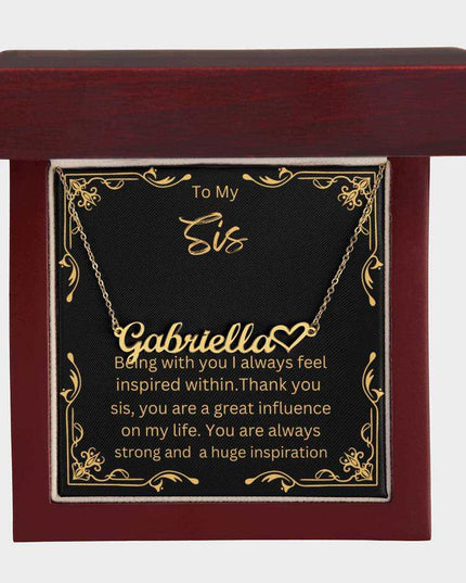 Name Heart Necklace with a yellow gold finish variant on a To Sis greeting card inside a mahogany box up close view