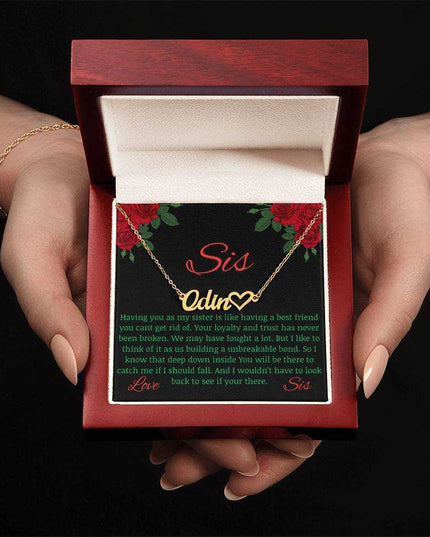 Name Heart Necklace with a yellow gold variant on a To Sis from Sis greeting card inside a mahogany box up close view in the hands of a model.