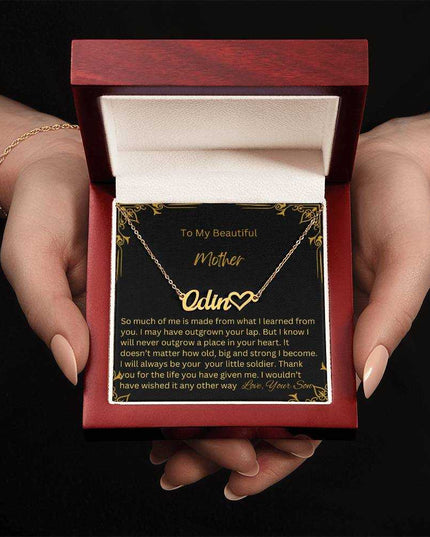 A yellow gold finish name heart necklace for mother in mahogany box being held