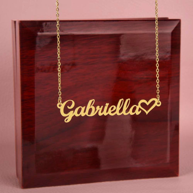 yellow gold name heart necklace on top of a closed luxury box 