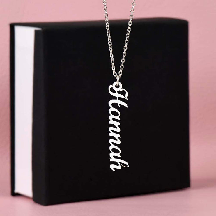 polished stainless-steel vertical name necklace on top of a soft box