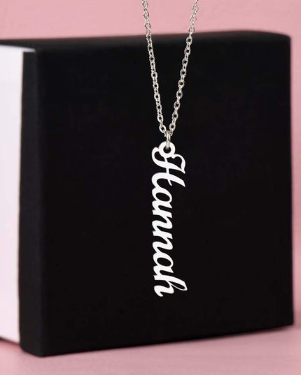 polished stainless-steel vertical name necklace on top of soft box
