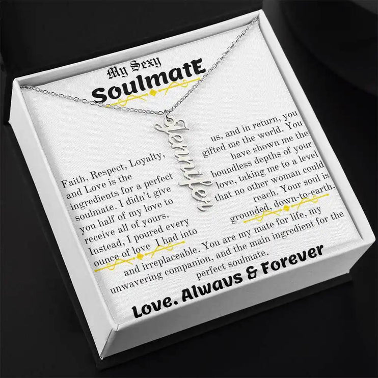 a polished stainless steel vertical name necklace in a two-tone box angled left