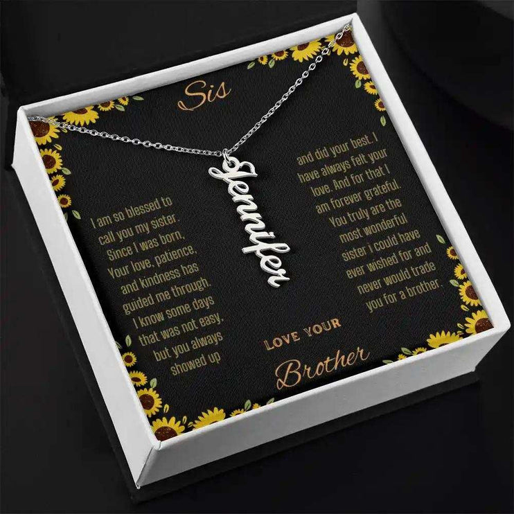 Vertical Name Necklace with a polished stainless-steel charm on a to sis from brother greeting card in a two-tone box angled slightly to the right