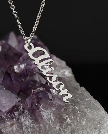 polished stainless-steel vertical name necklace on a quartz rock