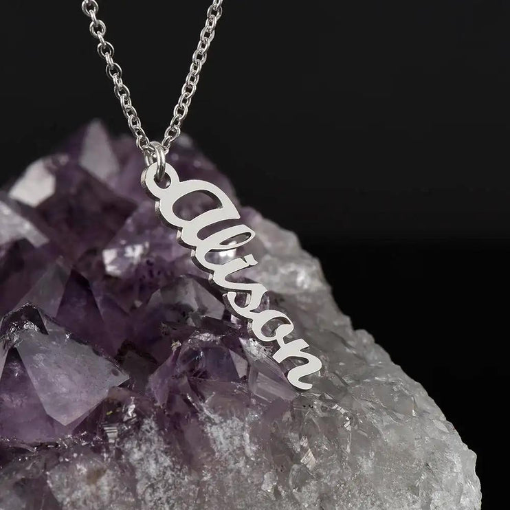 polished stainless-steel vertical name necklace on a quartz rock