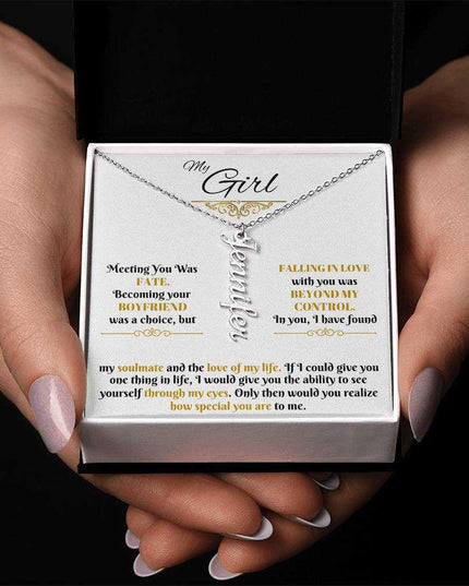 polished stainless-steel vertical name necklace in a soft box in hands