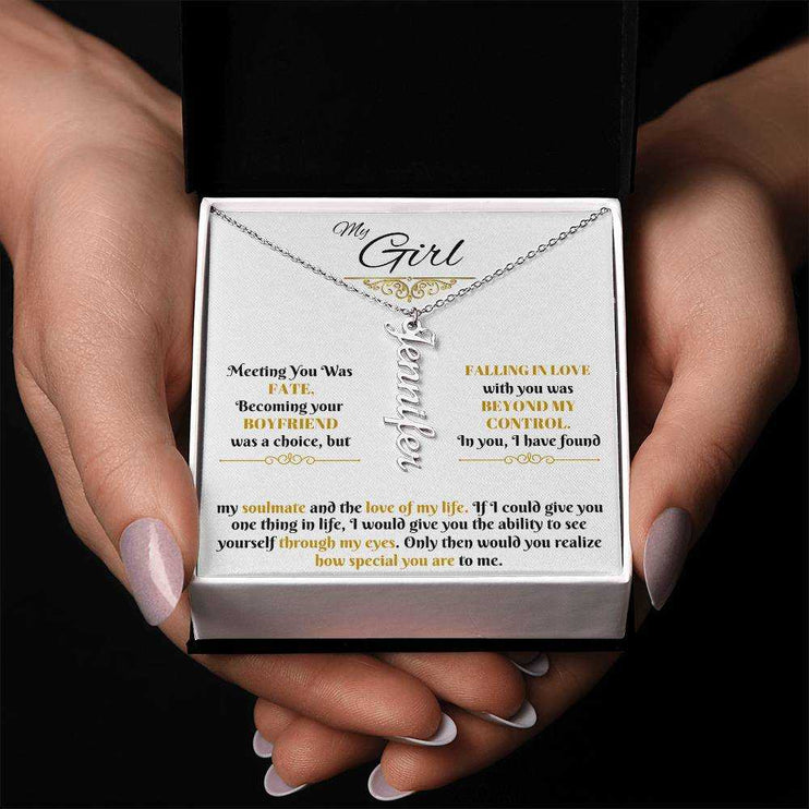 polished stainless-steel vertical name necklace in a soft box in hands