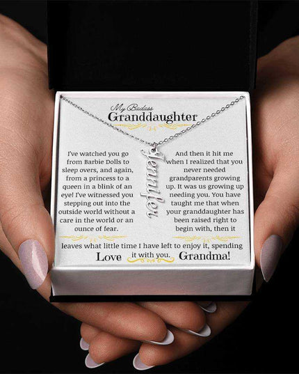 a polished stainless-steel vertical name necklace in a models hands