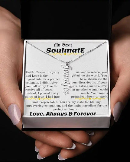 a polished stainless steel vertical name necklace in a models hands
