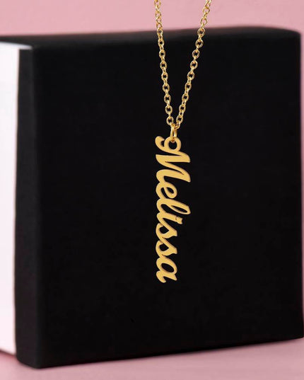 yellow gold vertical name necklace outside a soft box sitting upright