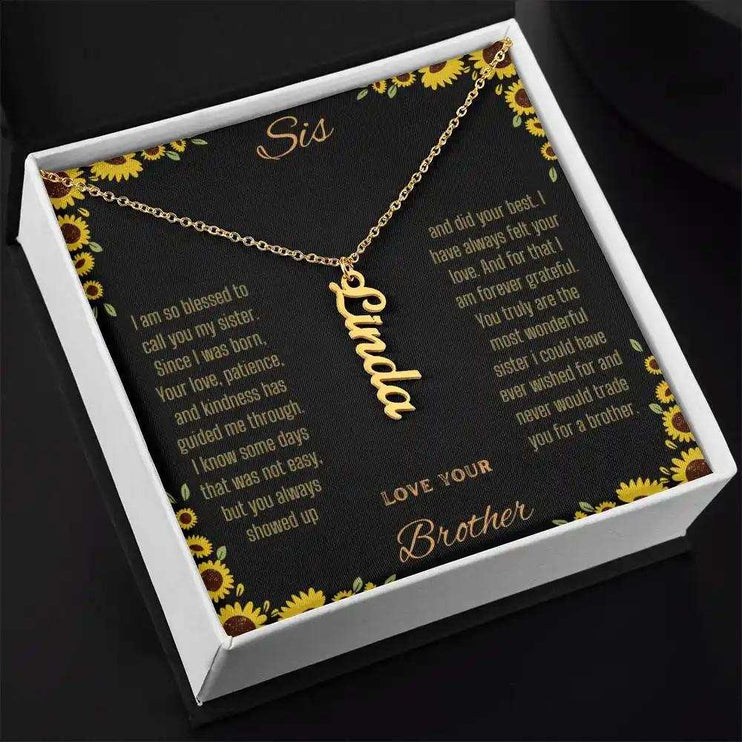 Vertical Name Necklace with a yellow gold finish charm on a to sis from brother greeting card in a two-tone box angled slightly to the right